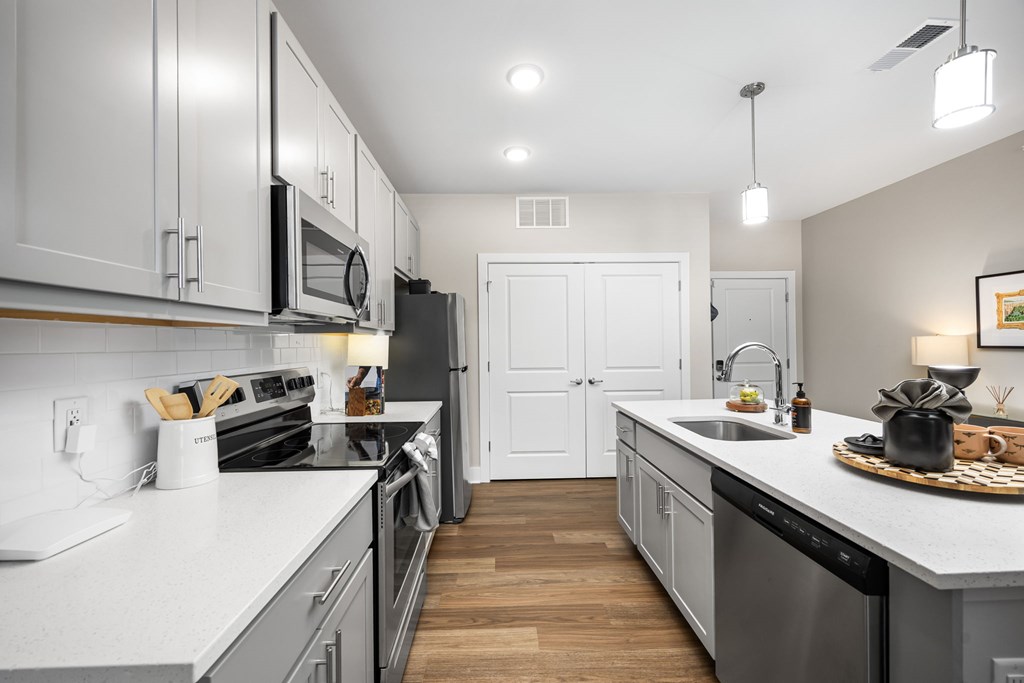 A modern kitchen with white cabinets and stainless steel appliances.