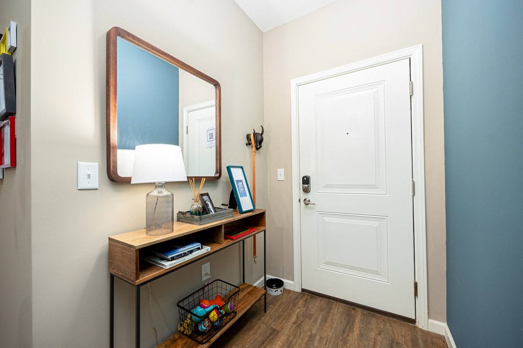 a hallway with a mirror and a desk with a door