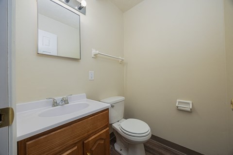 A white sink with a mirror above it and a toilet in a bathroom.