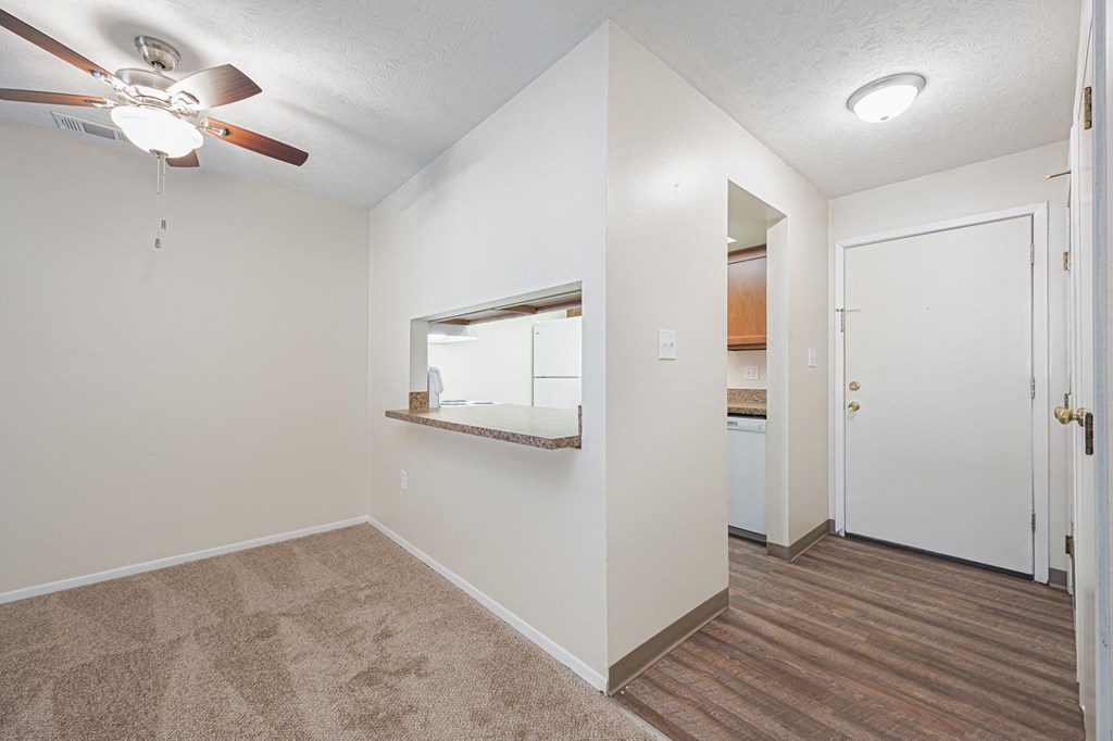 a bedroom with a ceiling fan and a door to a bathroom