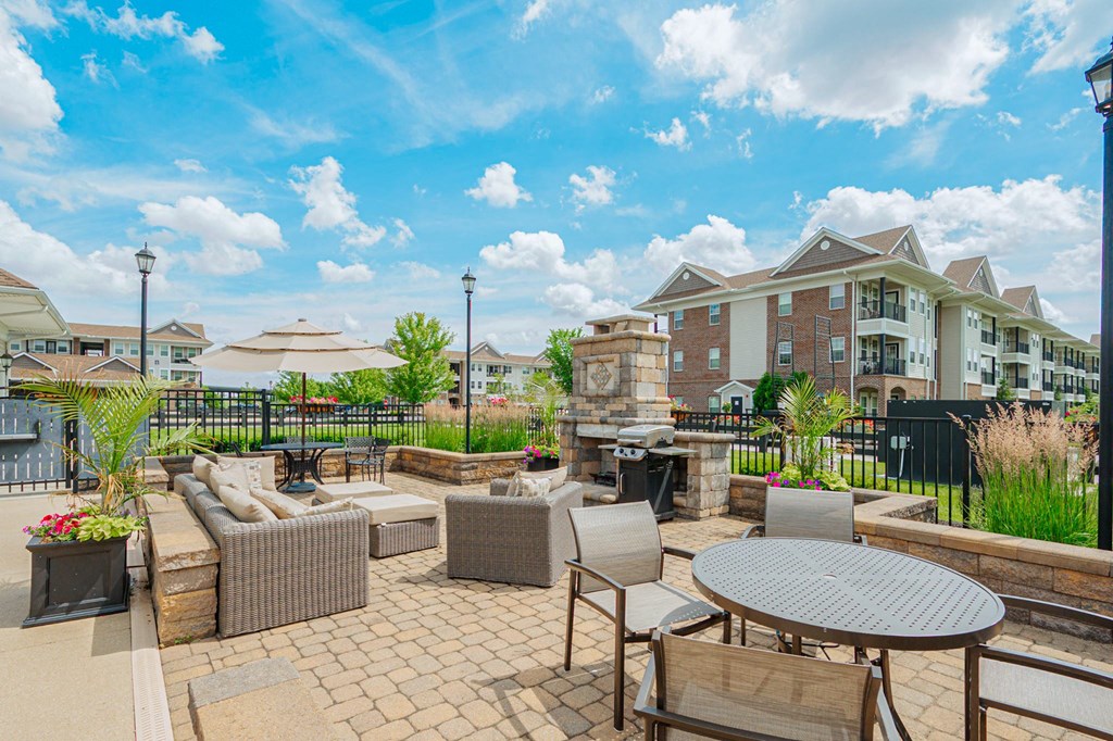 an outdoor patio with tables and chairs and a building in the background