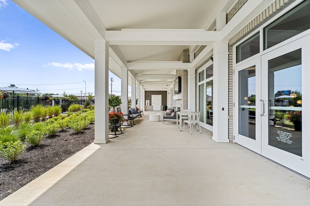 A long white covered walkway with tables and chairs on either side.