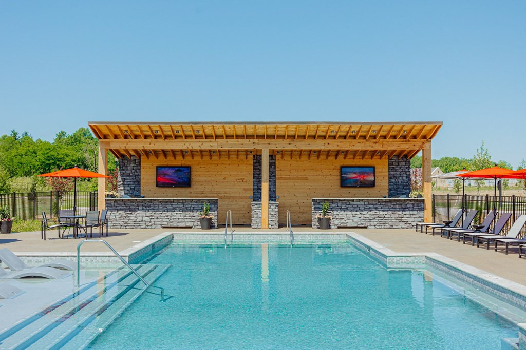 a swimming pool with a pergola next to a resort style pool
