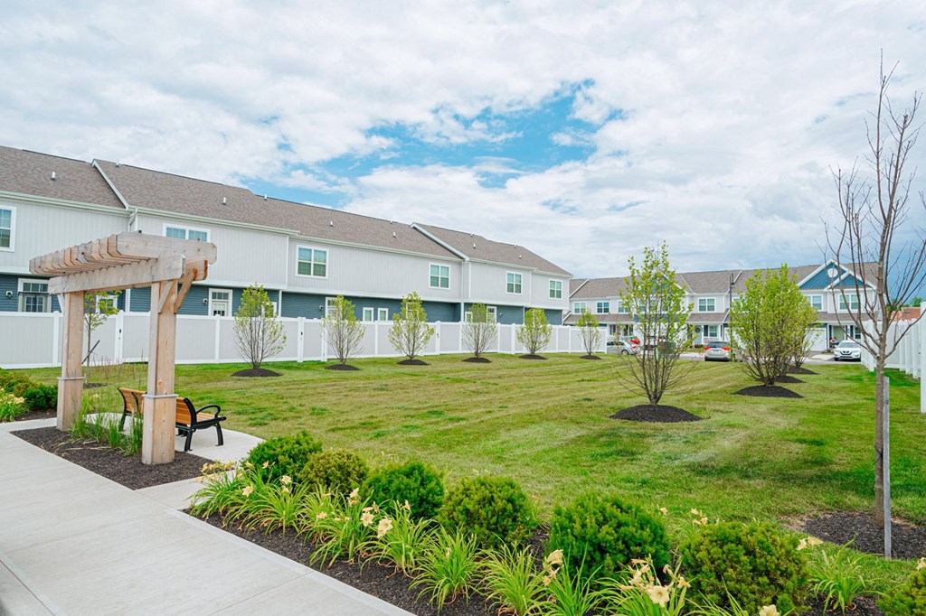 a park with a lawn and benches in front of a building