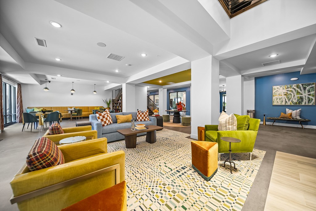 A spacious living room with a patterned rug and a variety of seating options.