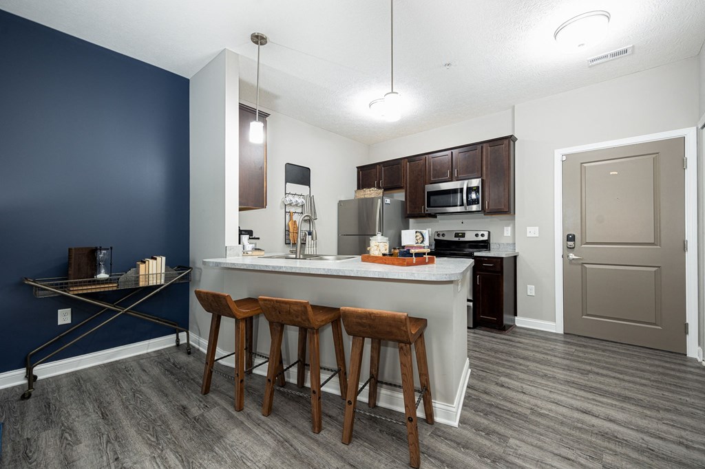 a kitchen with a large island with three stools