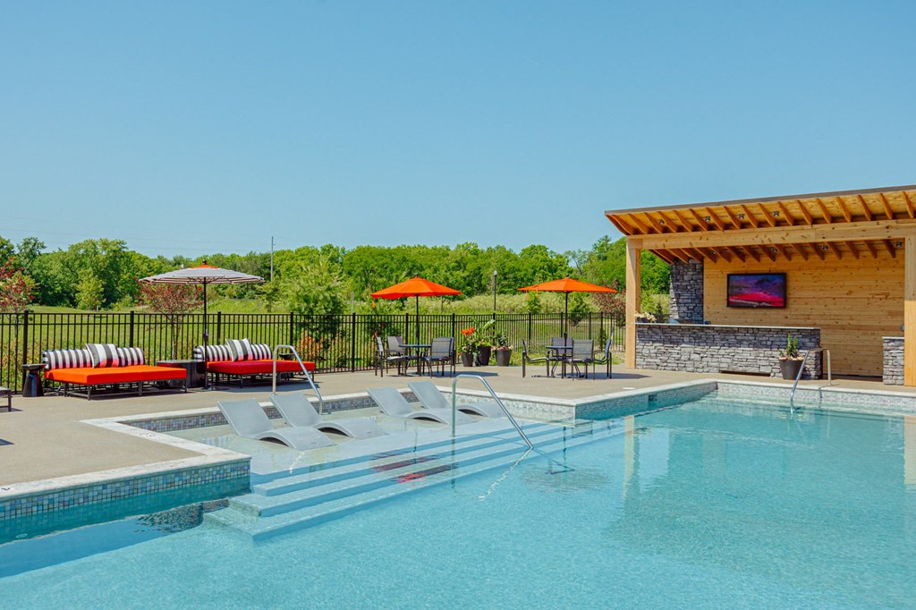 a swimming pool with chairs and umbrellas next to a resort style pool