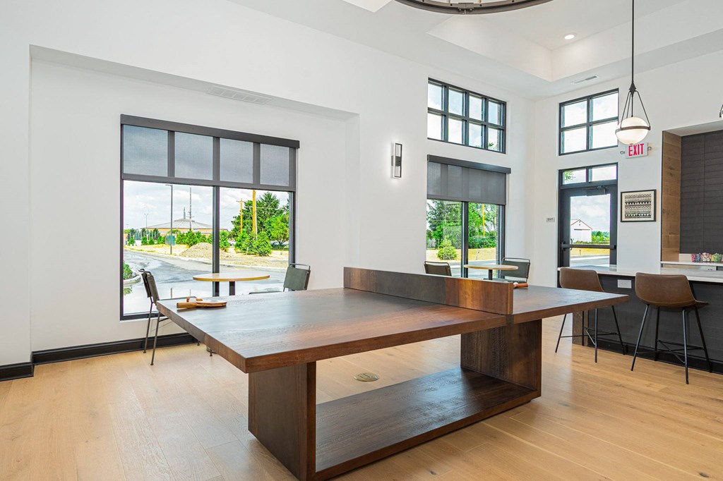 a dining room with a large table and chairs and windows