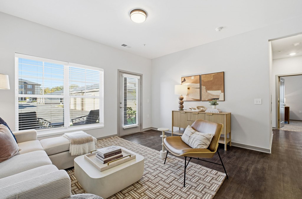 A living room with a white sofa, a chair, and a coffee table.