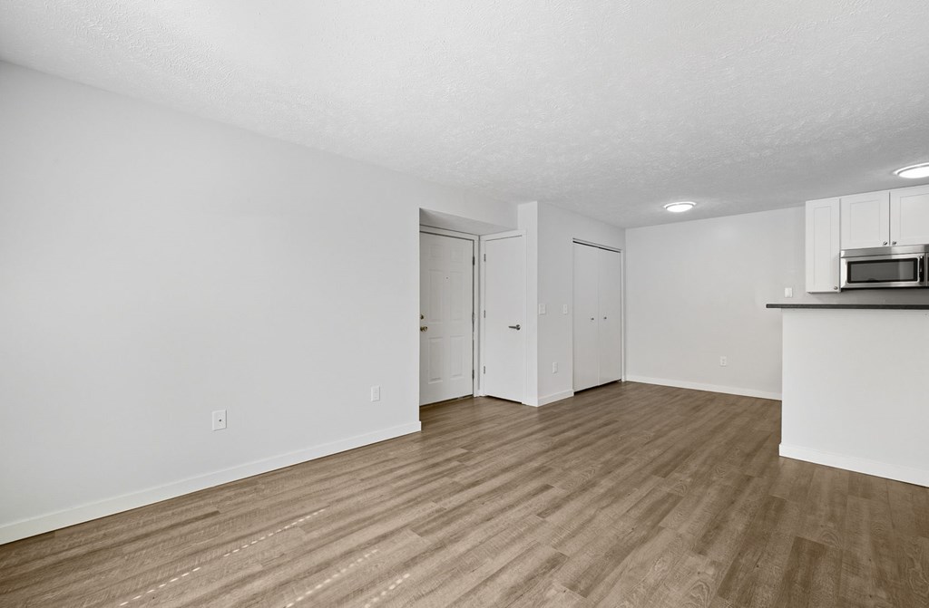 A room with wooden flooring and white walls.