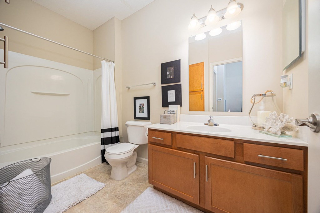 A bathroom with a toilet, sink, and mirror.