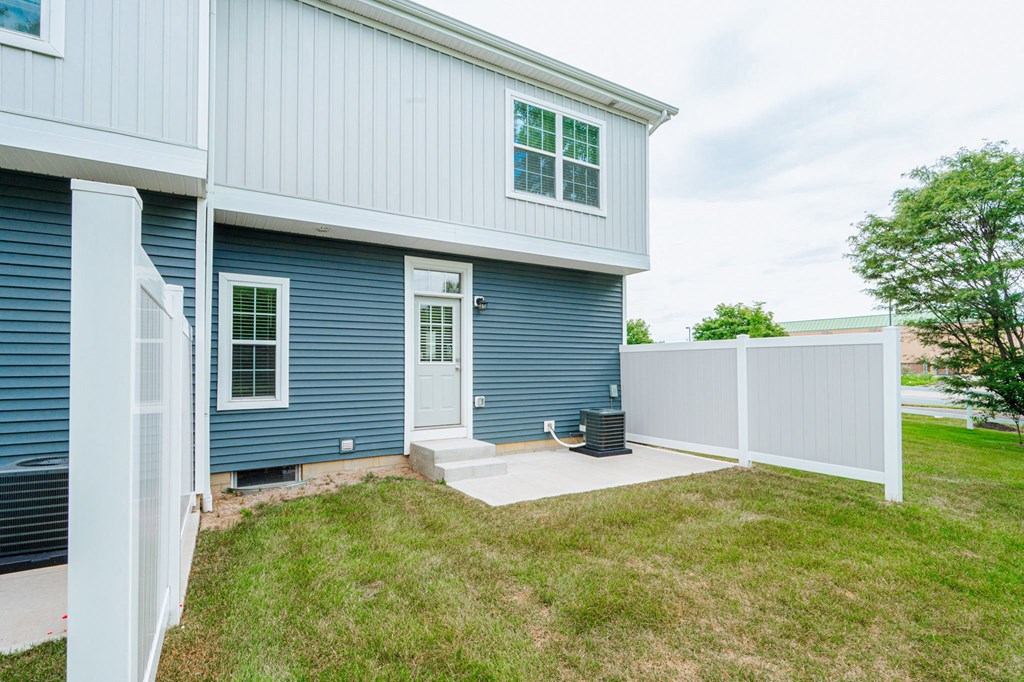 the front door of a blue house with a white fence