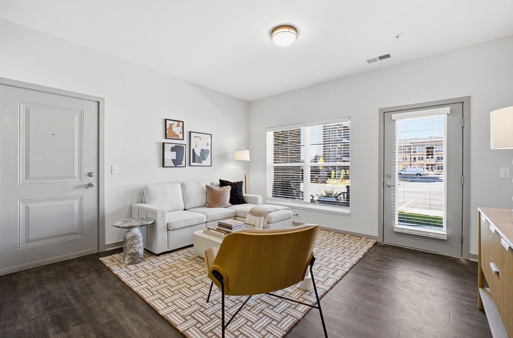 A living room with a yellow chair and a white sofa.