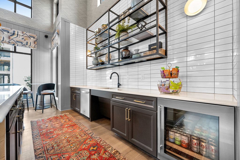 A modern kitchen with a large island and a rug on the floor.