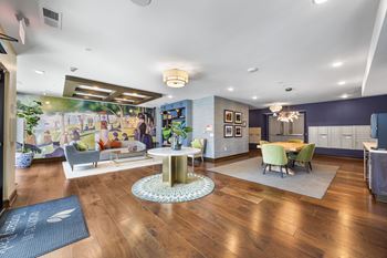 A spacious living room with a wooden floor and a large mural on the wall.