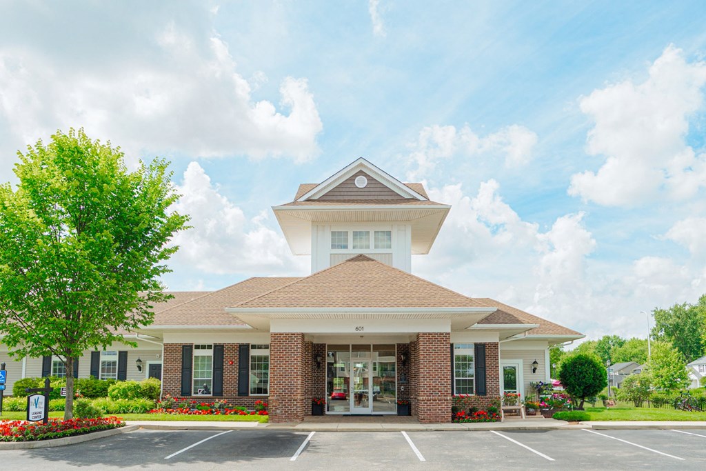 the exterior of a building with a parking lot and trees