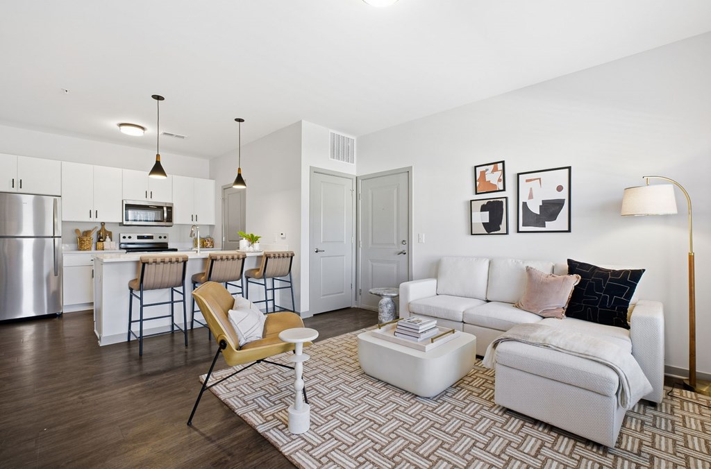 A modern living room with a white couch and a patterned rug.