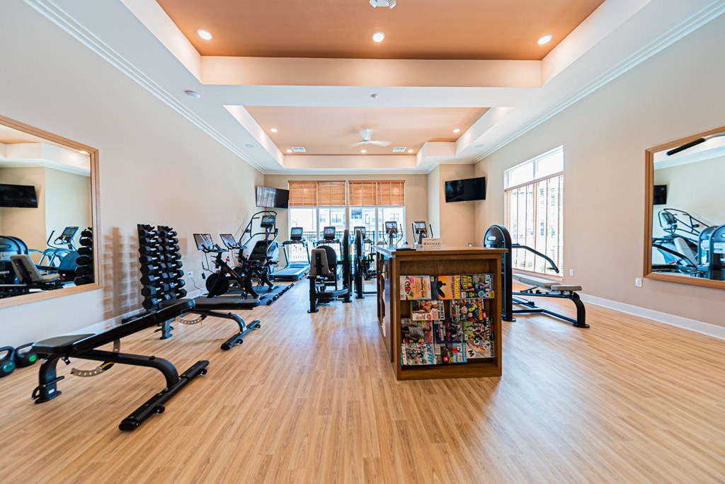 A gym with a variety of equipment including treadmills, weights, and exercise machines.