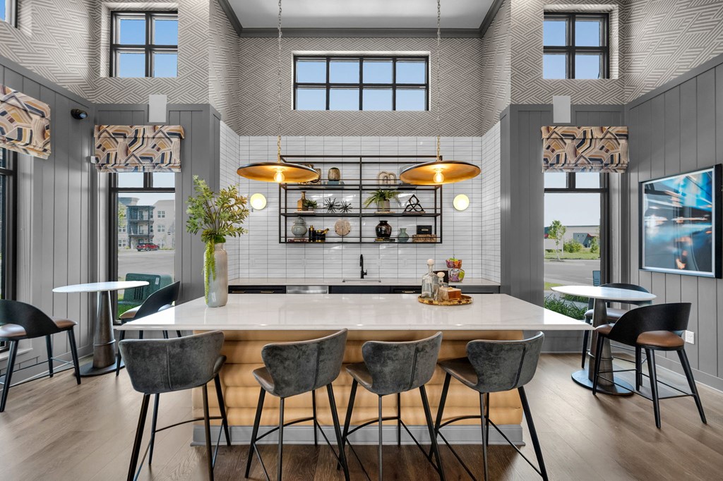 A modern kitchen with a large island and chairs.