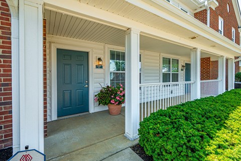 the front porch of a house with a blue door