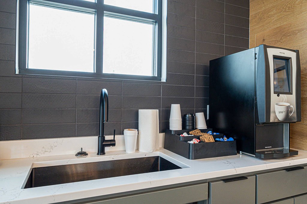 a kitchen with a sink and a coffee maker