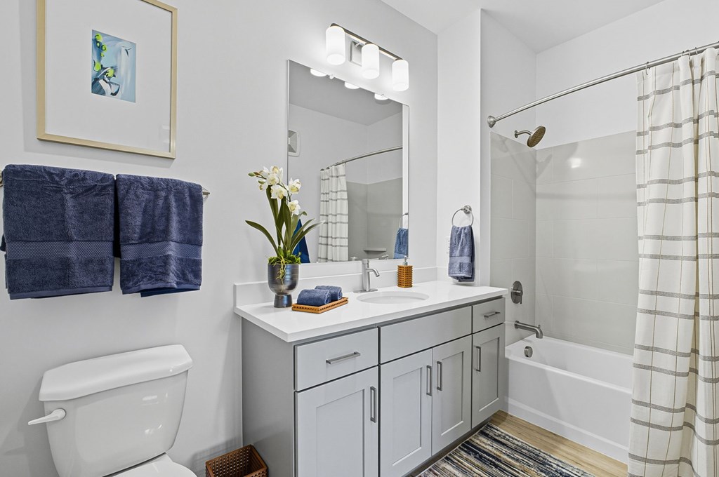 A white bathroom with a white toilet, white sink, and a white bathtub.