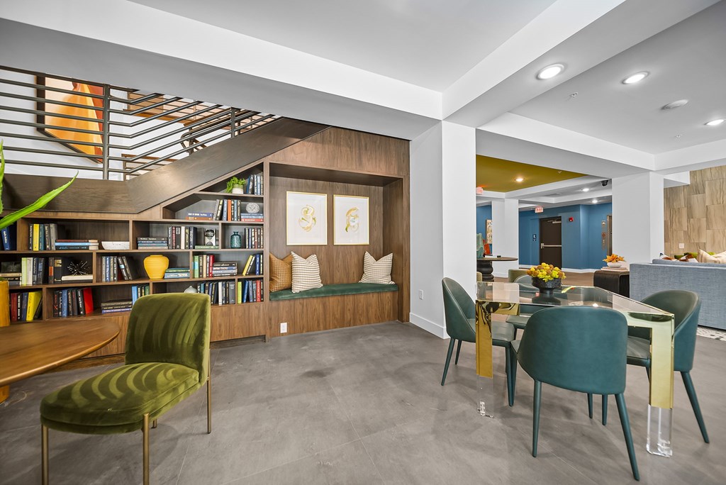 A modern living room with a green chair and a bookshelf.