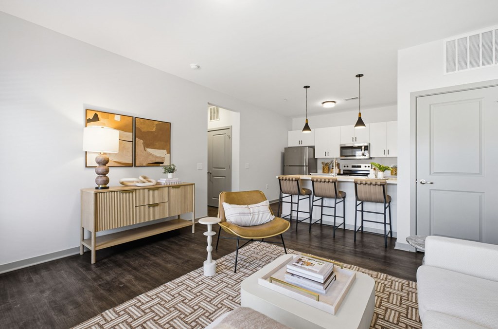 A living room with a white couch, a coffee table, and a dining table with chairs.