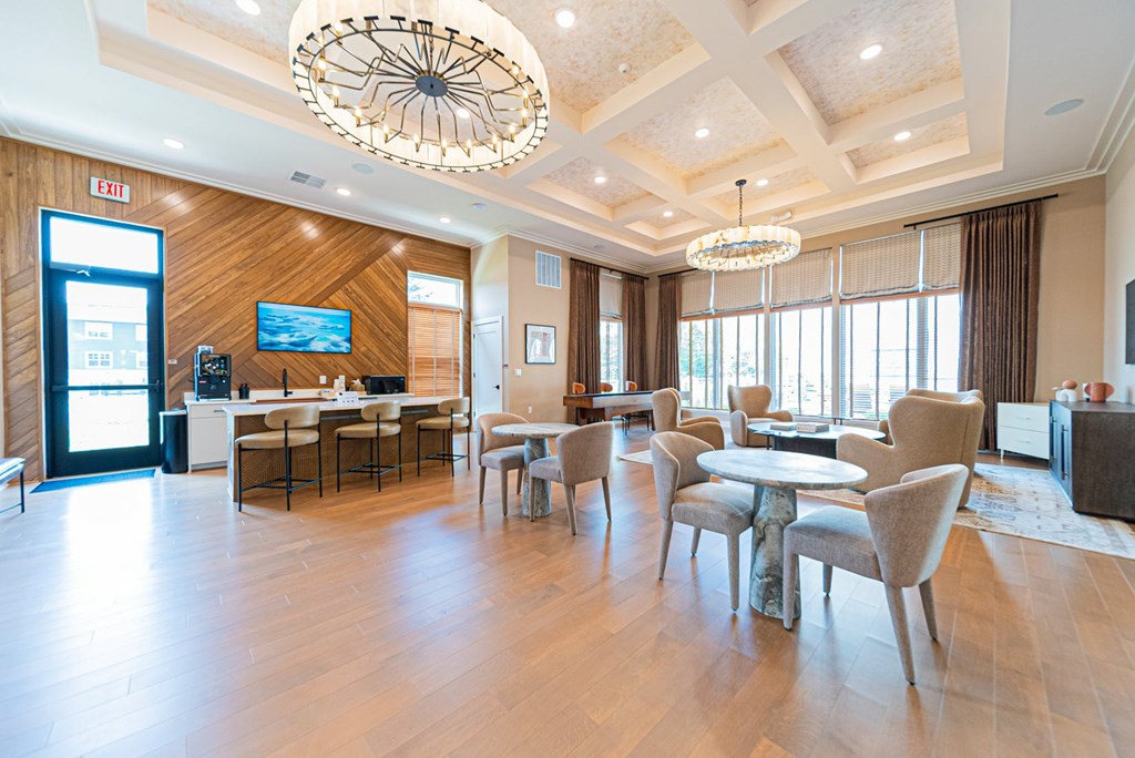 A large, well-lit room with a wooden floor and a chandelier hanging from the ceiling.