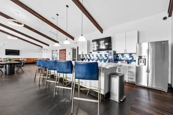 A kitchen with blue chairs and a white counter.