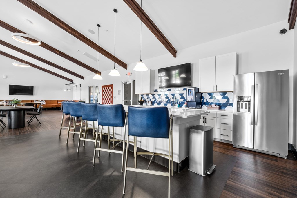 A kitchen with blue chairs and a white counter.