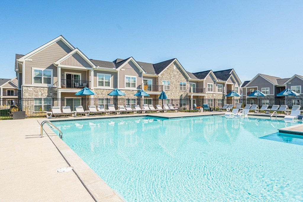 A large swimming pool in front of a row of houses.