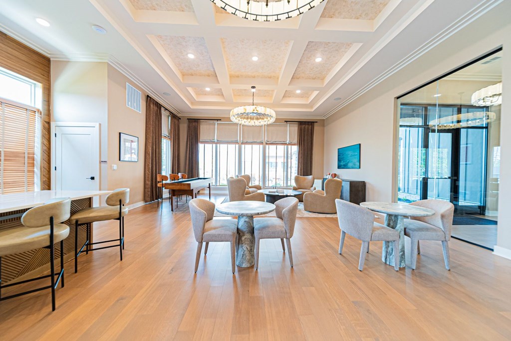 A large, well-lit dining room with a wooden floor and a chandelier.