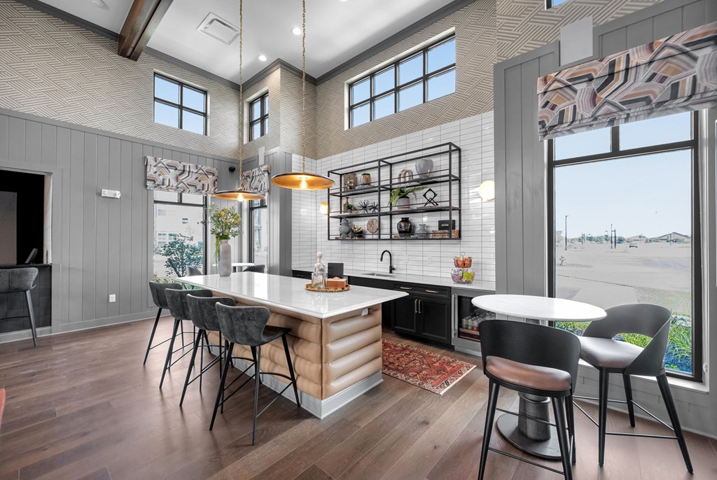 A modern kitchen with a large island and a dining table set up.