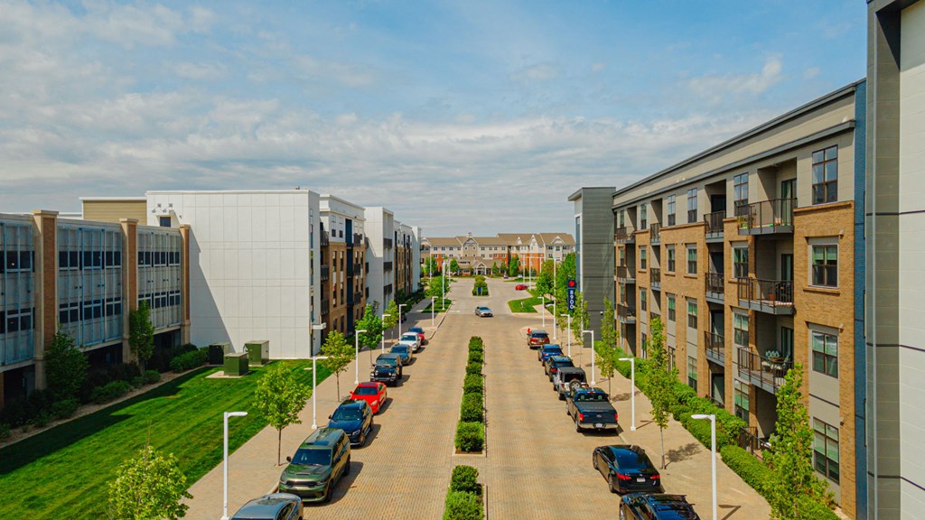 an aerial view of a street with cars parked in front of buildings