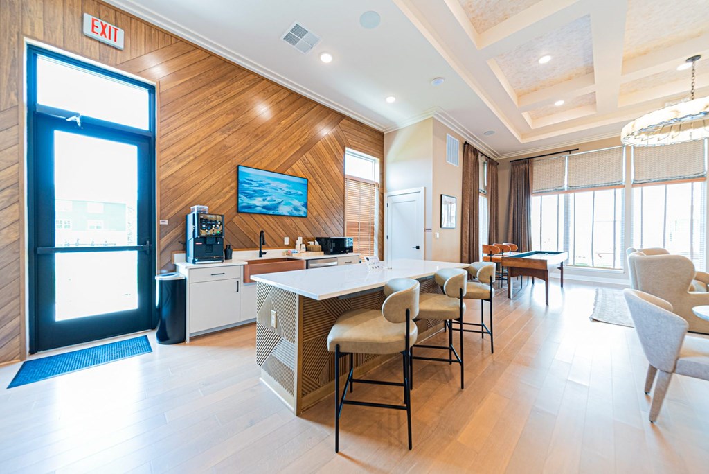 A modern kitchen with a bar area and a dining table.