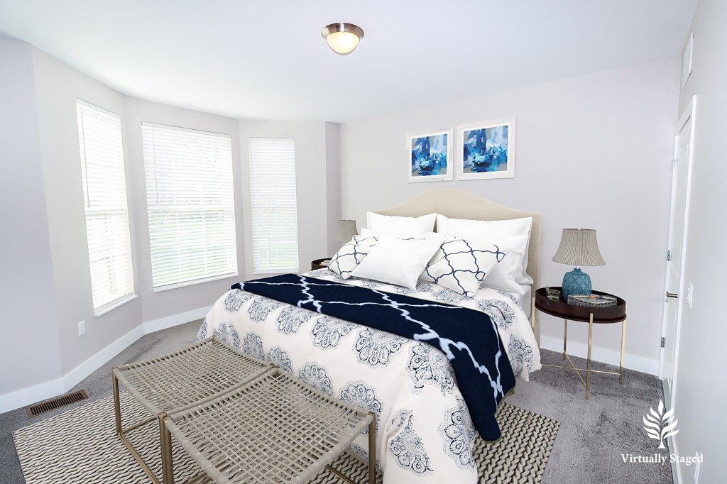 a bedroom with white walls and a large bed with a blue and white comforter