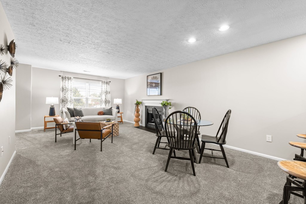 A living room with a grey carpet and furniture.