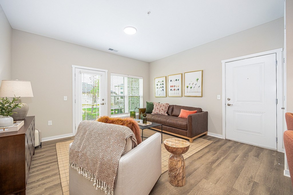 A living room with a couch, a chair, a table, and a lamp.