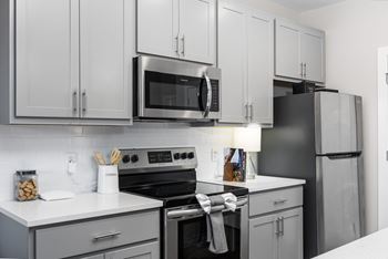 A modern kitchen with a black refrigerator and stove.