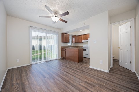 A room with a ceiling fan and wooden flooring.