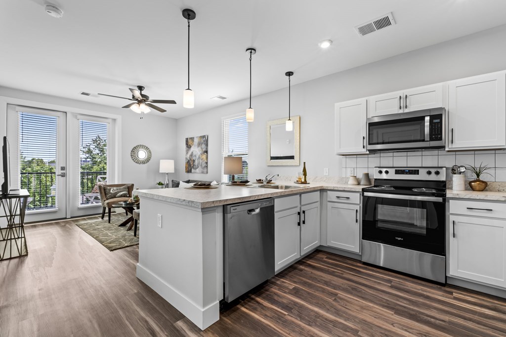 A modern kitchen with white cabinets and stainless steel appliances.