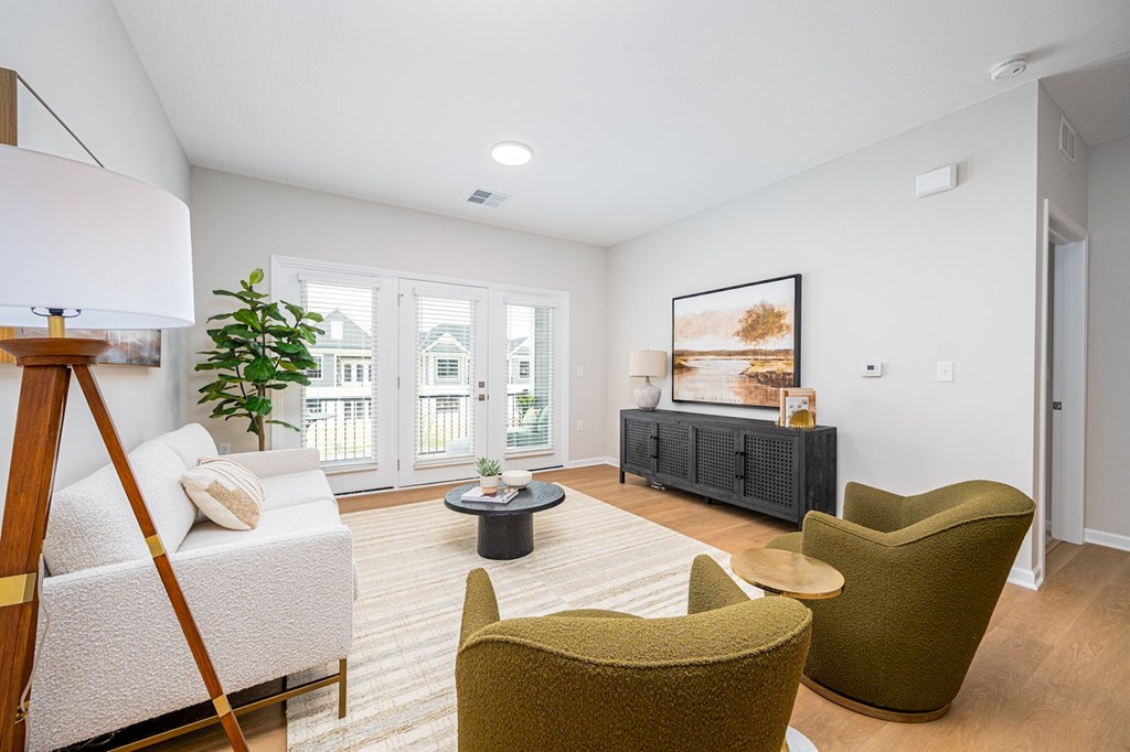 A living room with a white sofa, a green armchair, and a coffee table.