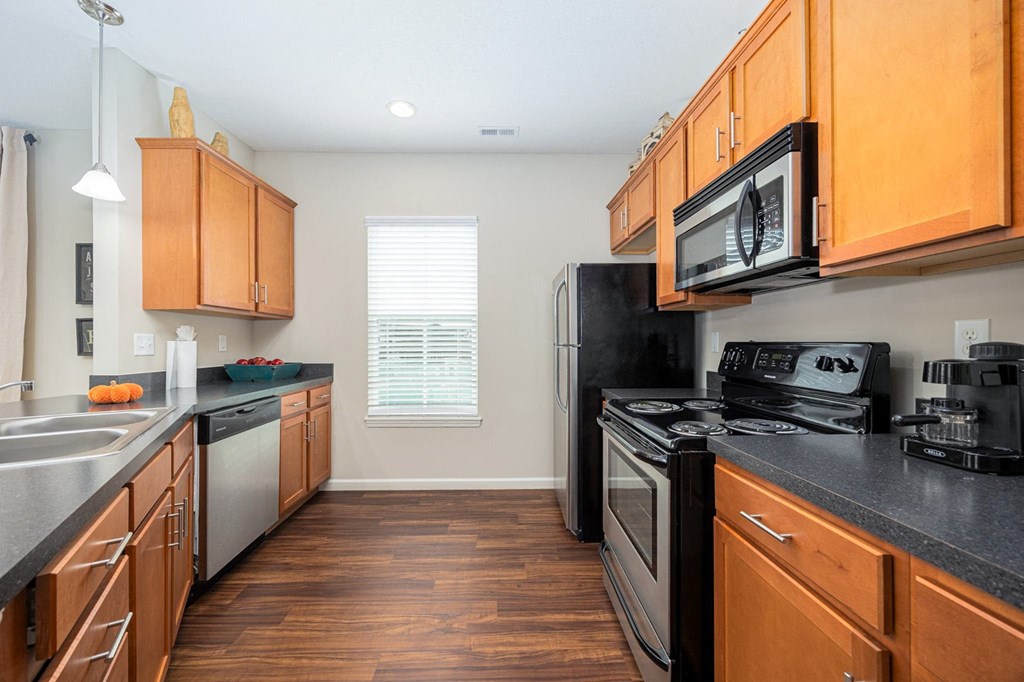 A kitchen with wooden cabinets and black appliances.