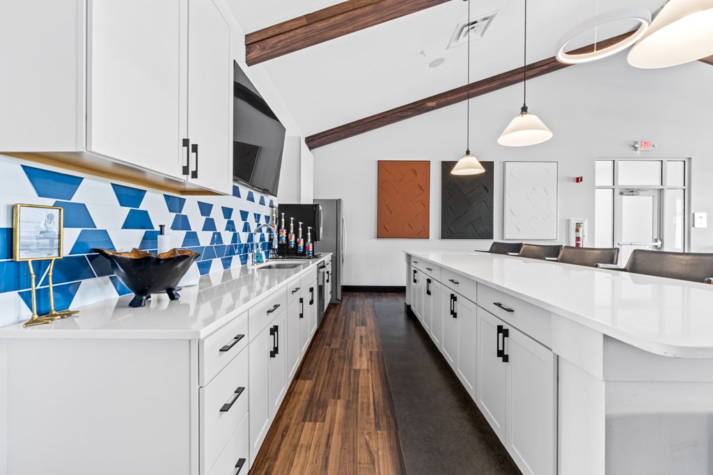A kitchen with white cabinets and a blue tile backsplash.