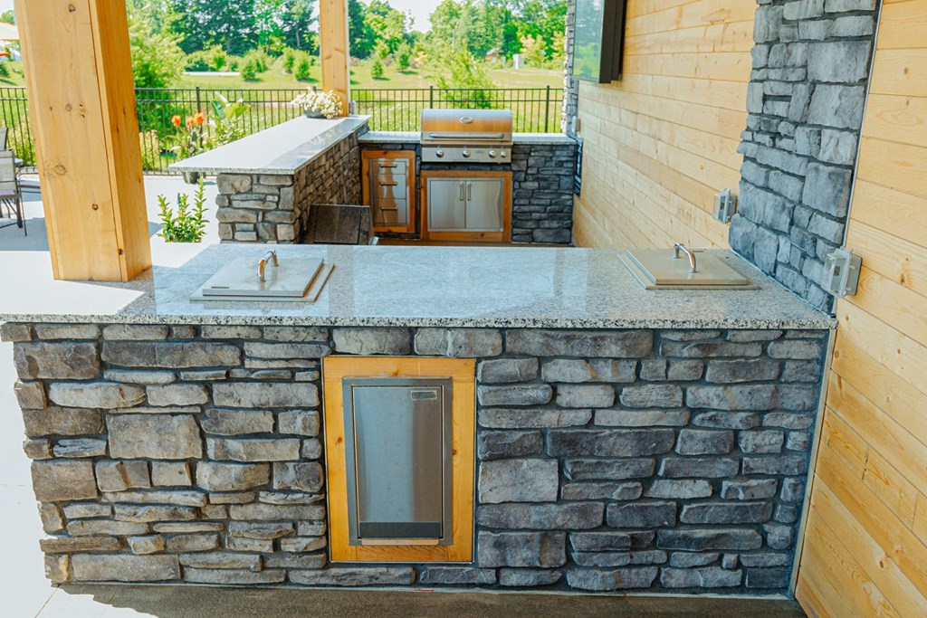 a stone bar with a grill on the side of a house
