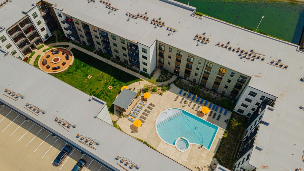 an aerial view of an apartment building with a swimming pool and a courtyard