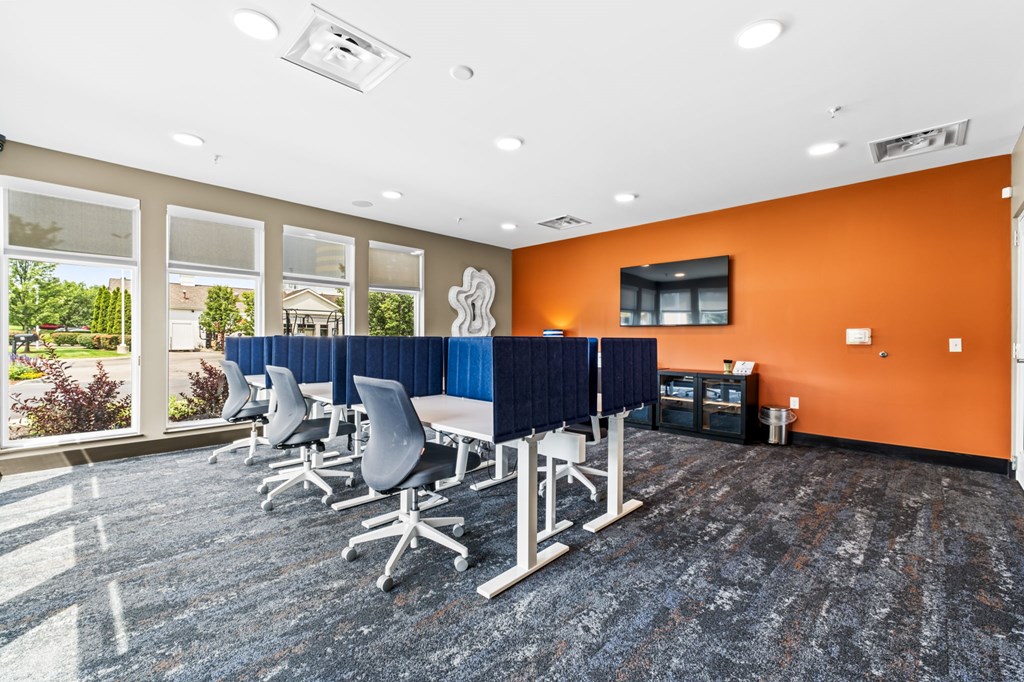 A conference room with orange walls and a long table with chairs.