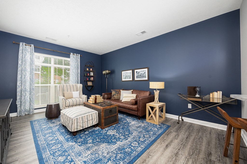 a living room with blue walls and a brown couch and chair
