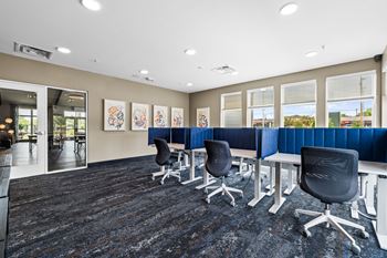 A conference room with a carpeted floor and a long table with chairs.